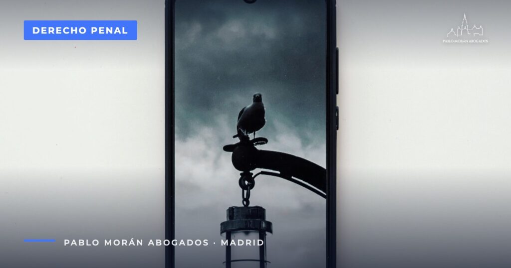 Teléfono móvil sobre una mesa blanca: amenazas por WhatsApp y redes sociales, abogado penalista en Madrid