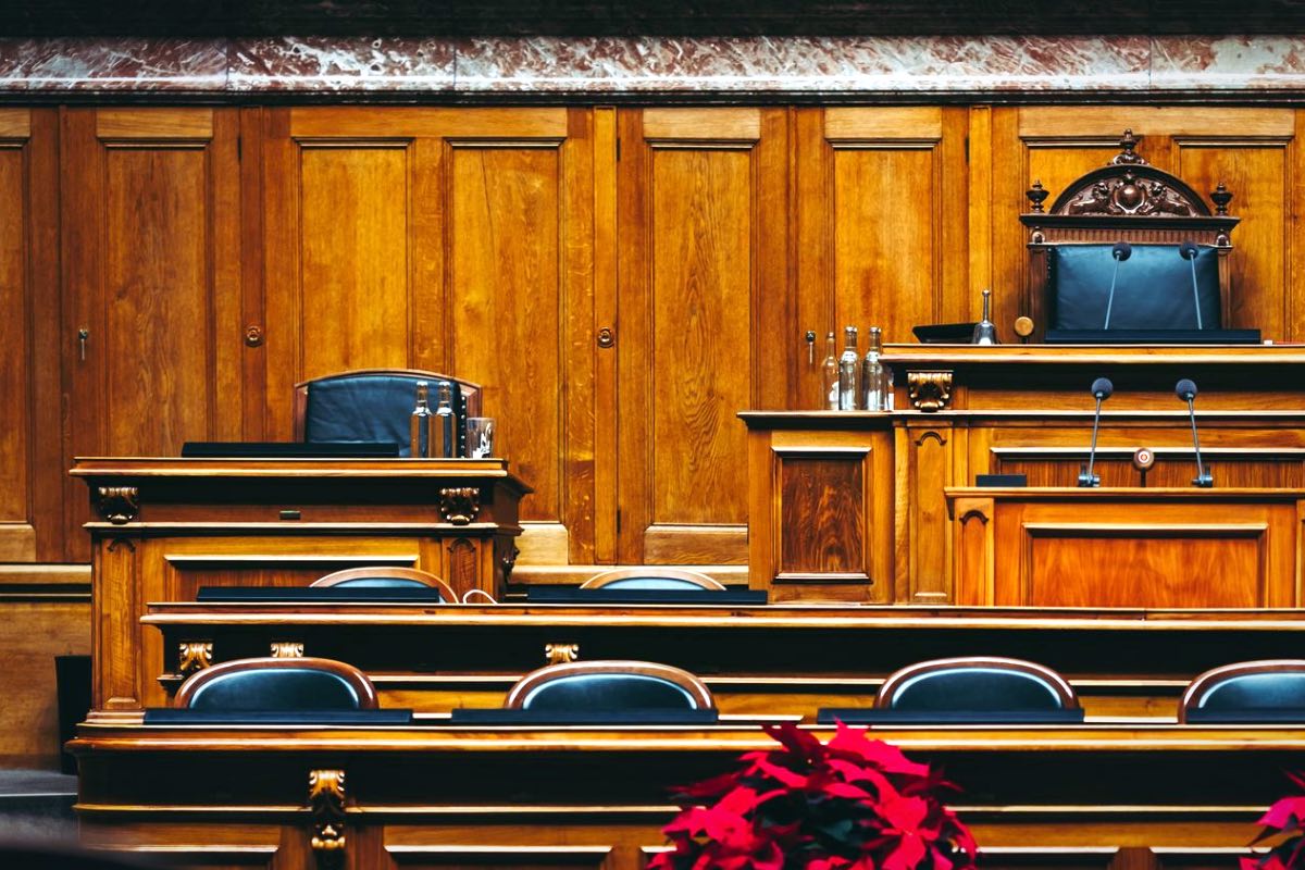 Estrado y bancos de madera de una sala de tribunal: abogado de competencia desleal entre empresas en Madrid