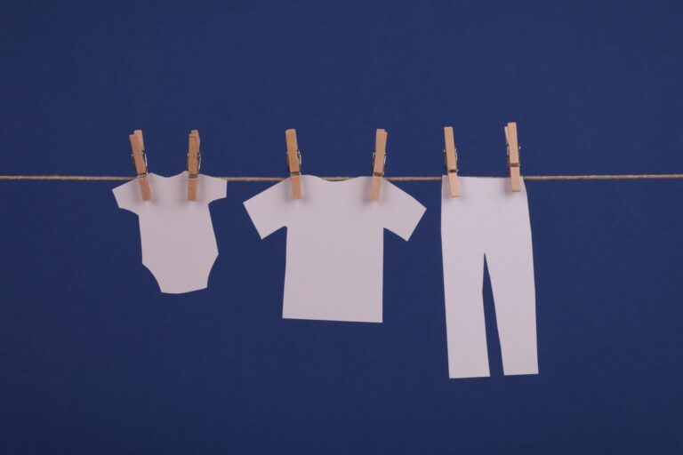 Ropa de bebé de papel colgada de una cuerda: abogado de custodia y pensión de alimentos en Madrid
