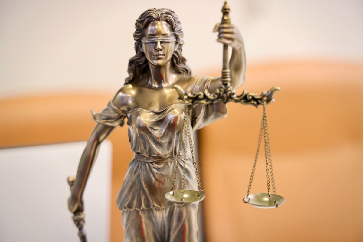 Estatua de la Justicia con la balanza: abogado de denuncia y acusación falsa en Madrid
