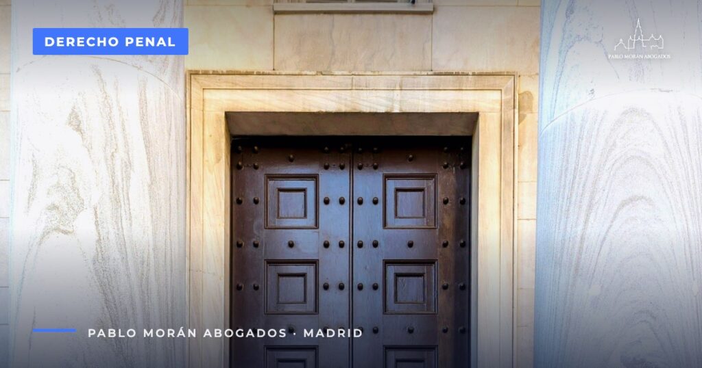Puerta de madera entre columnas de un edificio oficial: cómo y dónde presentar una denuncia, abogado penalista en Madrid