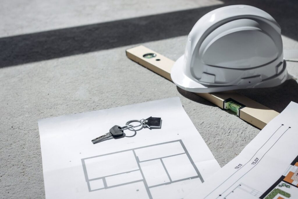 Casco de obra y nivel sobre planos: abogado de enfermedad profesional e incapacidad laboral en Madrid