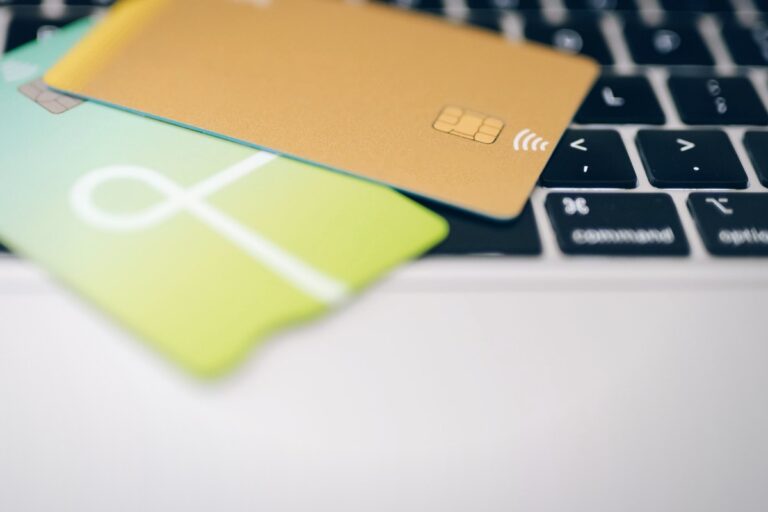Tarjetas bancarias sobre el teclado de un portátil: abogado de estafas y transferencias fraudulentas en Madrid