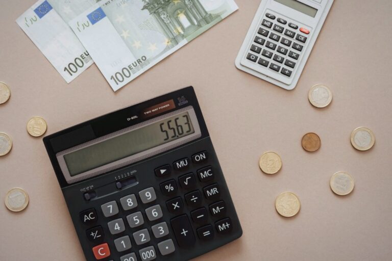 Calculadora sobre una mesa con monedas: abogado para reclamar el finiquito y la liquidación en Madrid