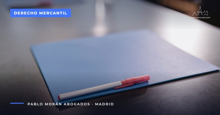 Carpeta azul con un bolígrafo rojo sobre una mesa oscura: impugnación de acuerdos sociales, abogado mercantilista en Madrid