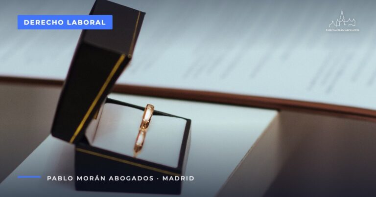 Alianzas de boda en una caja abierta sobre una mesa: permisos retribuidos por matrimonio, fallecimiento u hospitalización, abogado laboral en Madrid