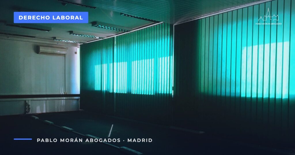 Sala de oficina vacía con persianas verdosas: prestación por desempleo tras un despido, abogado laboral en Madrid