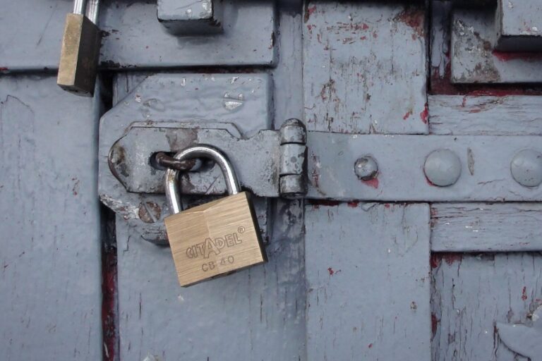 Candado en el pestillo de una puerta de madera: cómo proteger tu vivienda frente a los okupas, abogado en Madrid