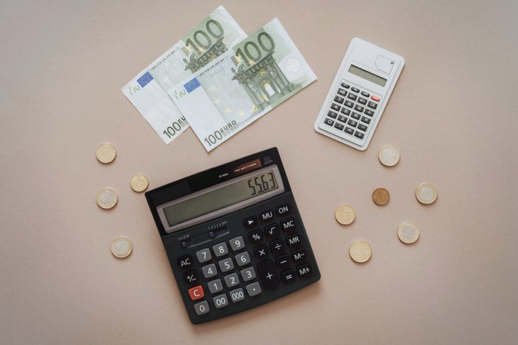 Calculadora, billetes y monedas de euro: abogado para reclamar salarios impagados en Madrid