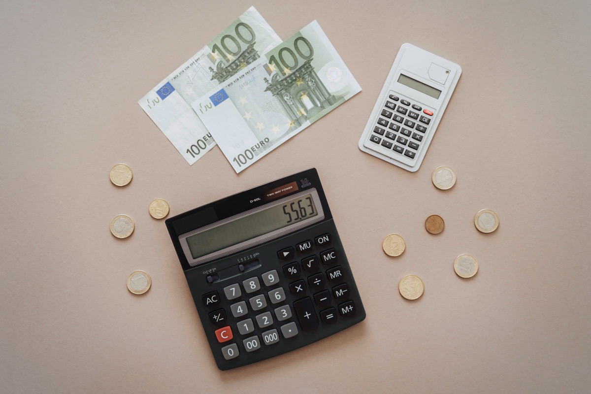 Calculadora, billetes y monedas de euro: abogado para reclamar salarios impagados en Madrid