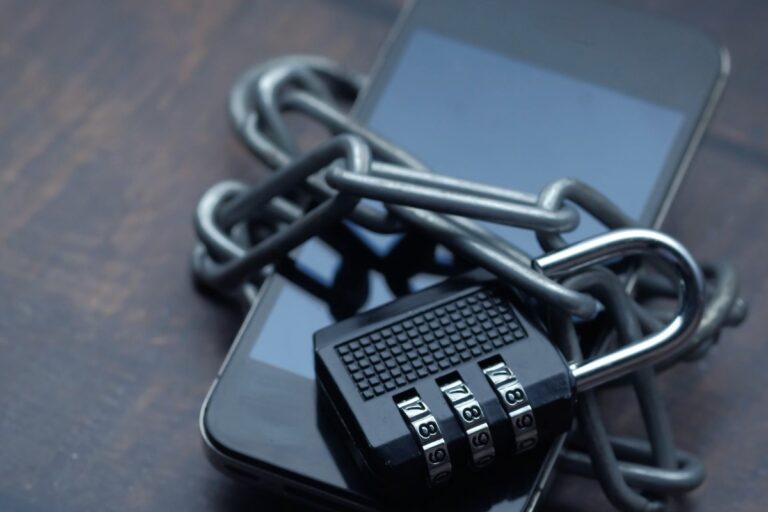 Teléfono móvil con cadena y candado de combinación: abogado de smishing, vishing y fraude bancario en Madrid