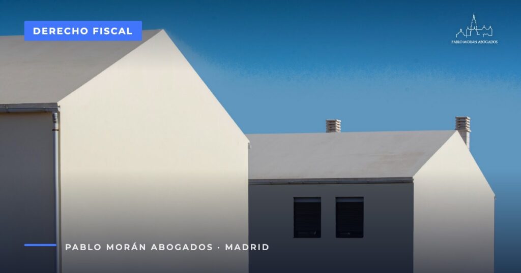 Dos casas blancas contra un cielo azul: vender una vivienda, impuestos y exenciones, abogado fiscalista en Madrid