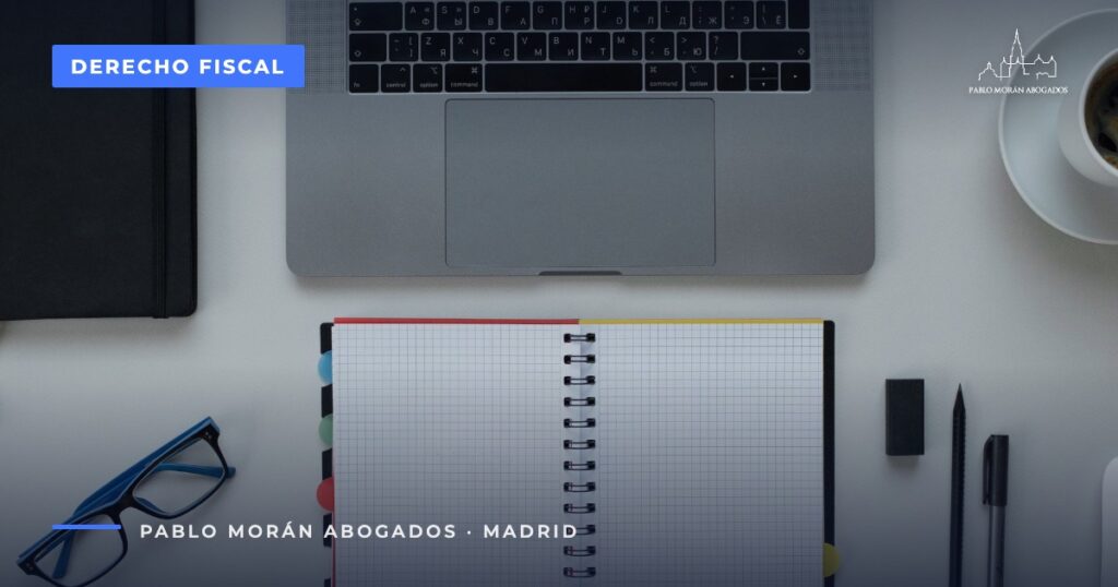 Mesa de trabajo con cuaderno y portátil: deducciones del IRPF para autónomos en Madrid