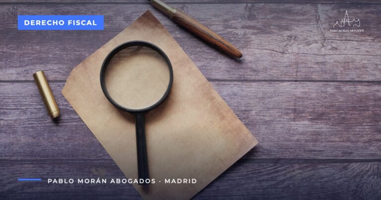 Lupa y pluma sobre un papel: cómo recurrir una sanción de Hacienda, abogado fiscalista en Madrid